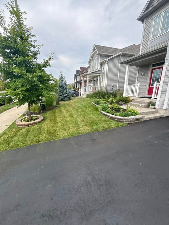 Manicured front lawn with landscaped garden beds by SJ Scapes